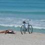 Heerlijk zonnen naast je fiets op het strand