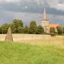 Twee van de zeven stenen met het kerkje van Västra Strö op de achtergrond